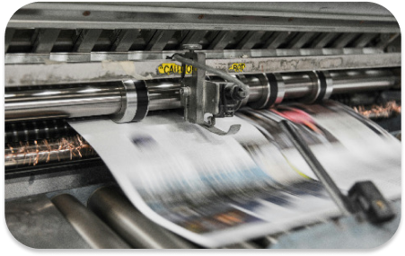 A printing press producing some artwork, the image is blurry where there is movement from the printing press