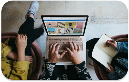 A person typing on a laptop, the perspective is from the picture being taken from above.