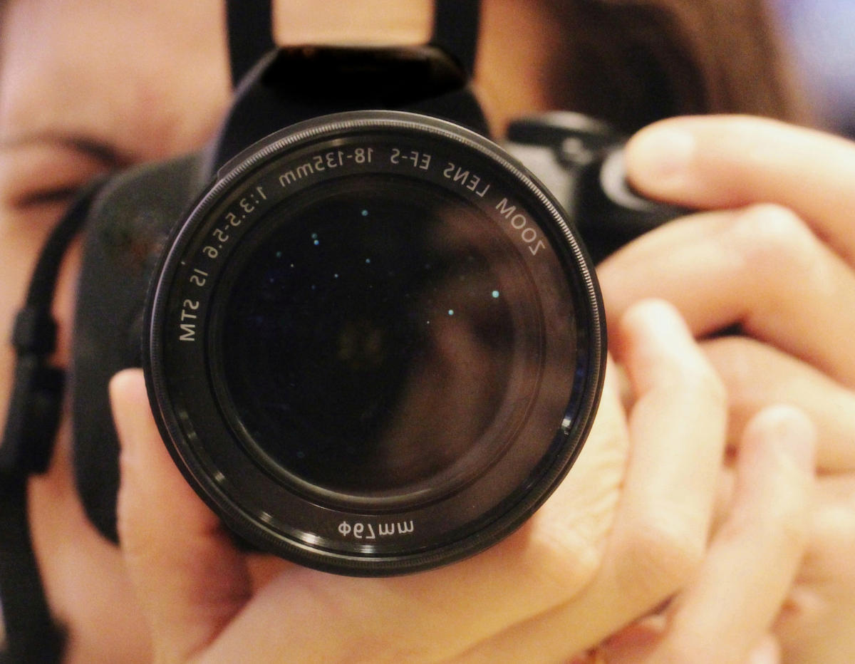 A close up of a woman holding a camera ready to take a photograph.