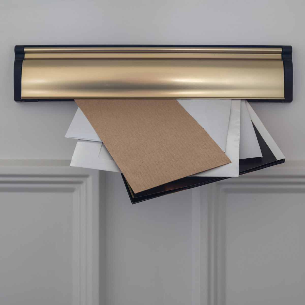 A selection of letters protruding through a letterbox on a front door.